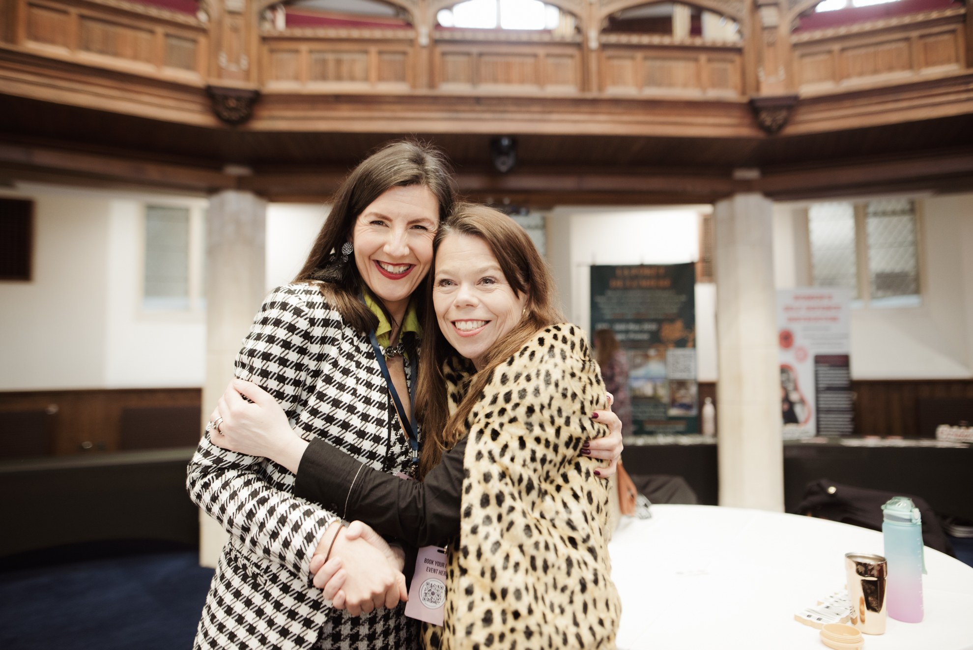 Two attendees sharing a hug at the event