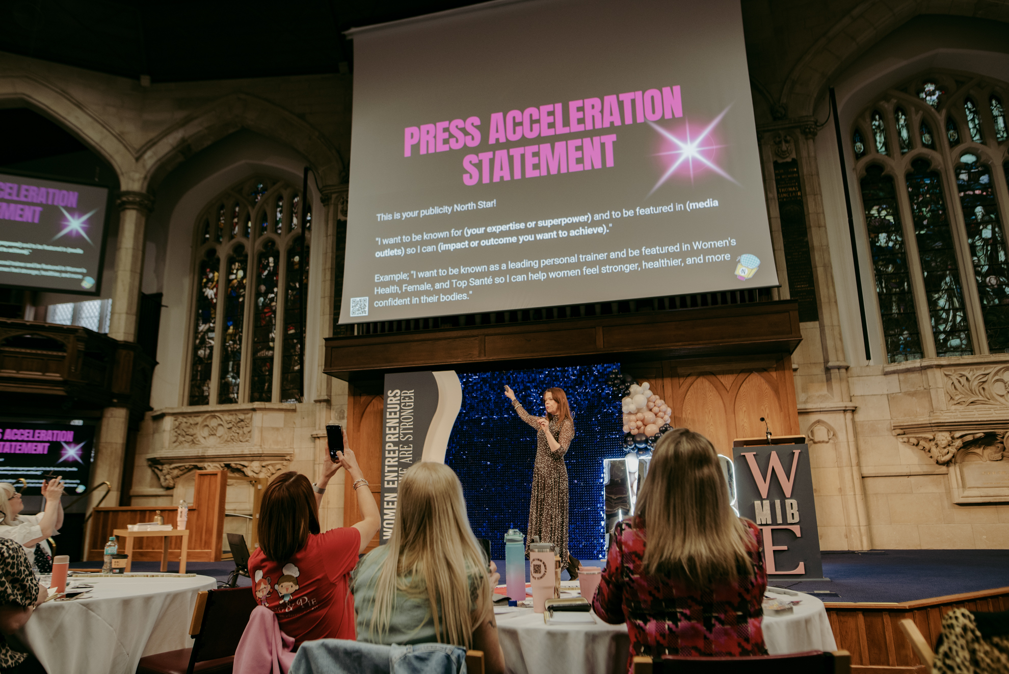 A speaker on stage presenting to the room