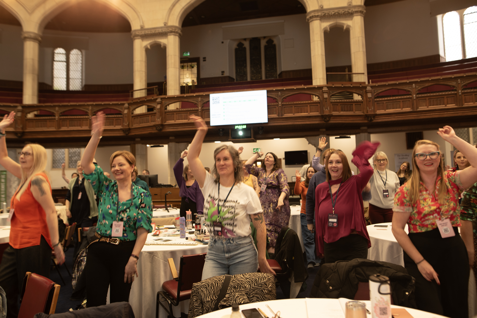 Attendees with hands in the air during an energetic session