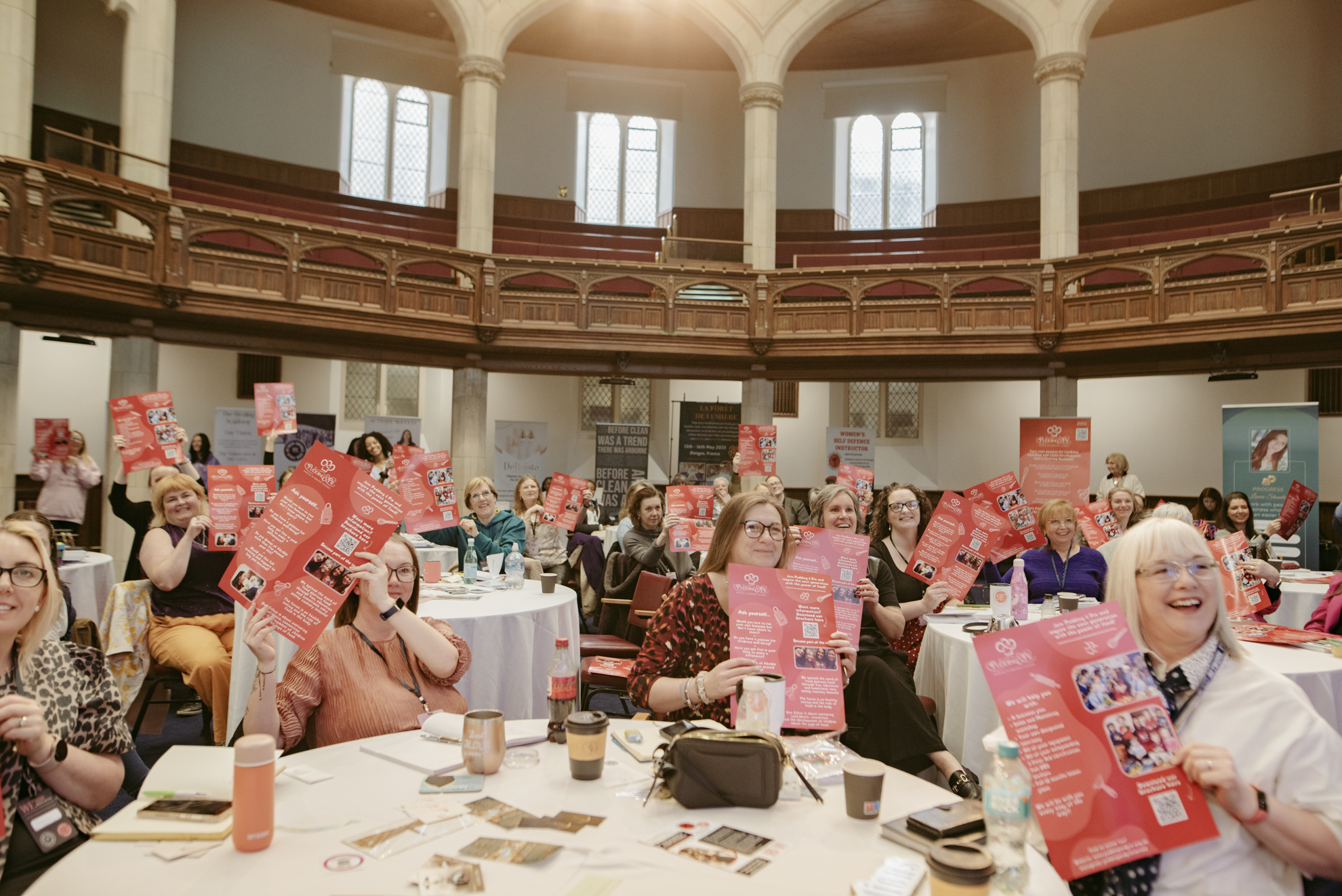 Tables of attendees holding up event materials